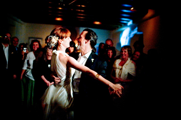 the happy couple dancing their first dance at the reception - bride is wearing a ivory feather hairpiece - photo by New Mexico based wedding photographers Twin Lens